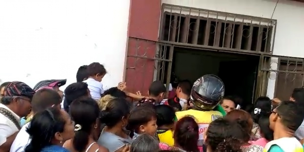 Cientos de personas intentaron ingresar apretujándose por una puerta.