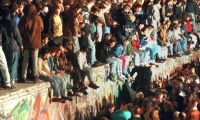 Jóvenes sobre el Muro de Berlín.